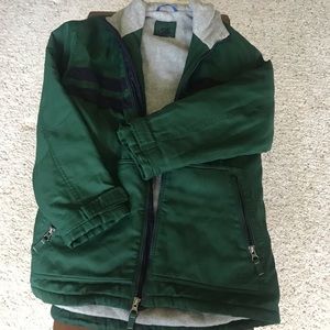 Green zip-up jacket with two navy blue stripes.